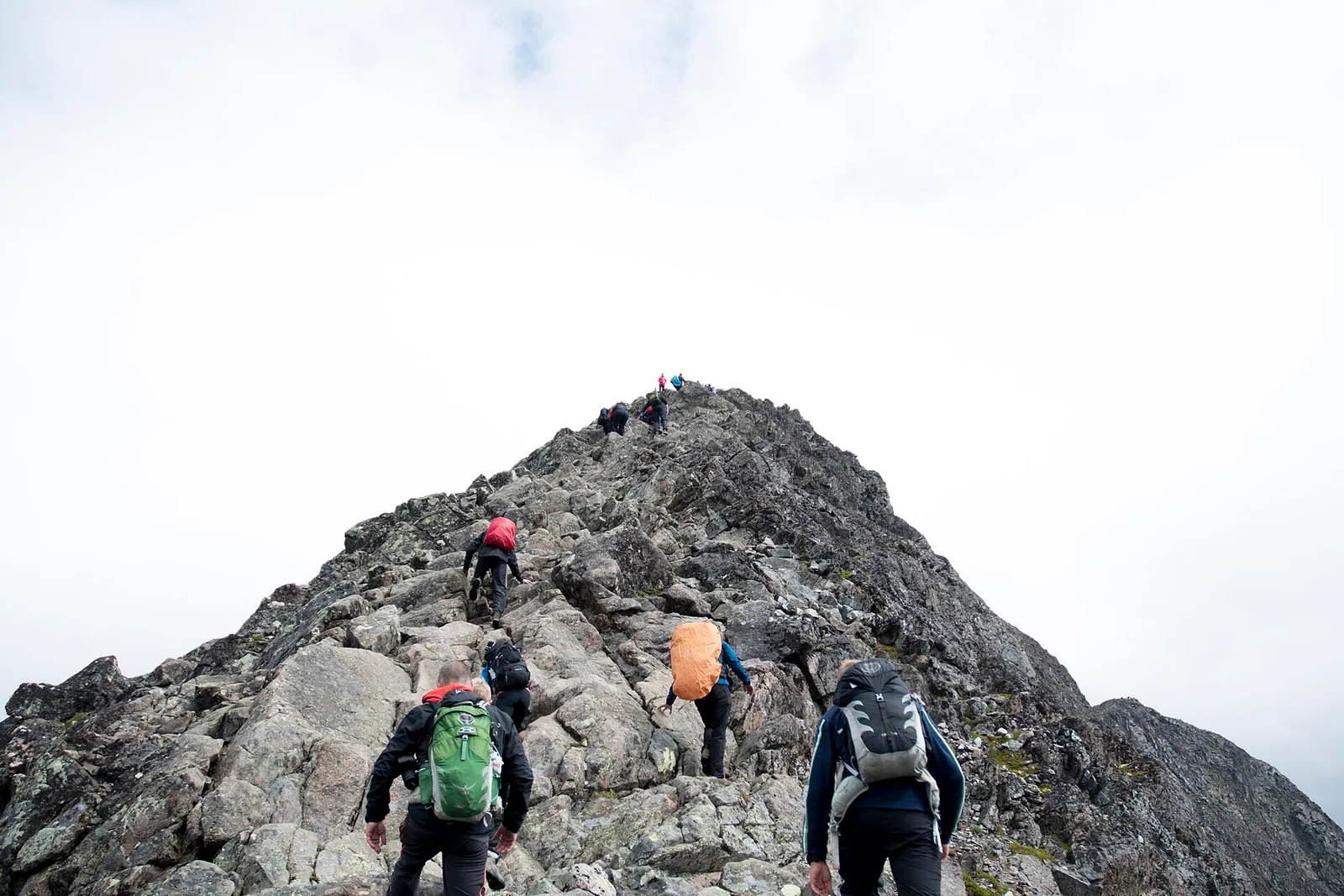 A group of travelers hiking across a mountain ridge